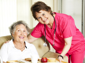 caretaker serving food to an elderly woman