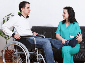 caretaker helping a man in wheelchair